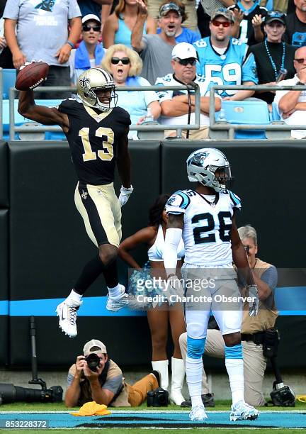 New Orleans Saints wide receiver Michael Thomas, left, leaps into the air to spike the ball after catching a touchdown pass from quarterback Drew...