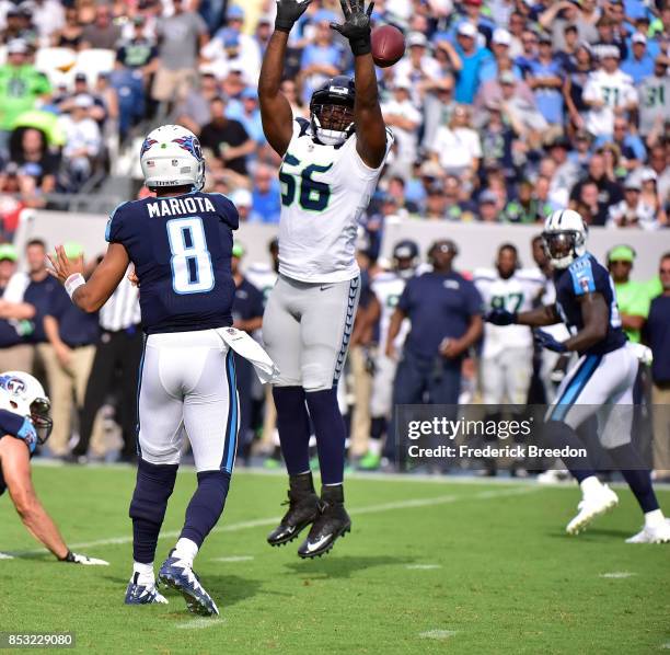Cliff Avril of the Seattle Seahawks jumps while attempting to block a pass by quarterback Marcus Mariota of the Tennessee Titans during the first...