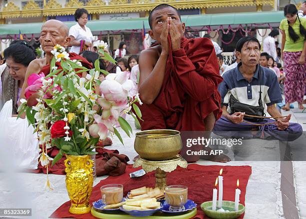 Myanmar people and monks offer prayers and meditate as they gather at the famous Shwedagon Pagoda on the occasion of the Tabaung Full Moon Festival,...
