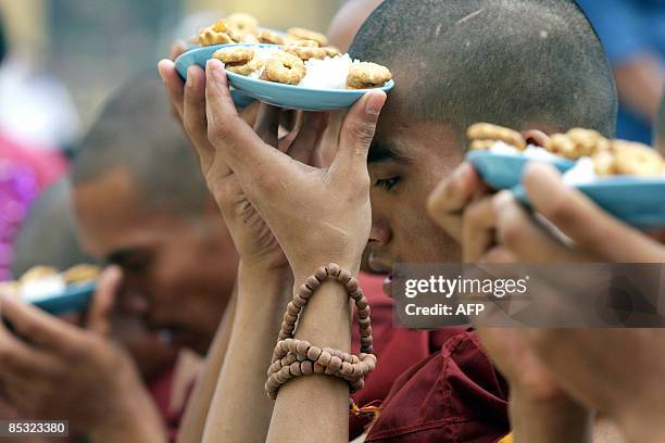 Myanmar monks present offerings as they gather at the famous Shwedagon Pagoda in Yangon on the occasion of the Tabaung Full Moon Festival, on March...