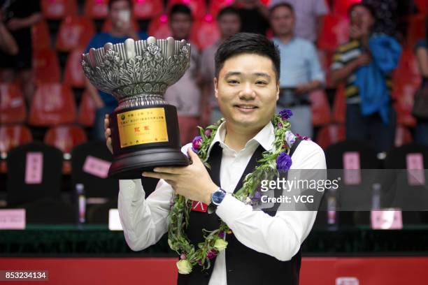 Ding Junhui of China celebrates with his trophy after winning the final match against Kyren Wilson of England on day seven of the World Open 2017 on...