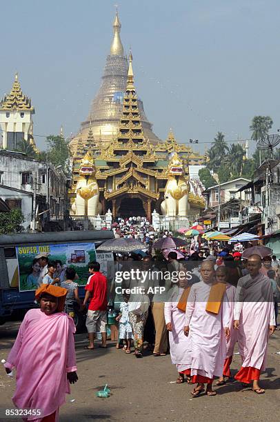 Buddhist nuns walk outside the famous Shwedagon Pagoda in Yangon to mark the occasion of the Tabaung Full Moon Festival on March 10, 2009. During the...
