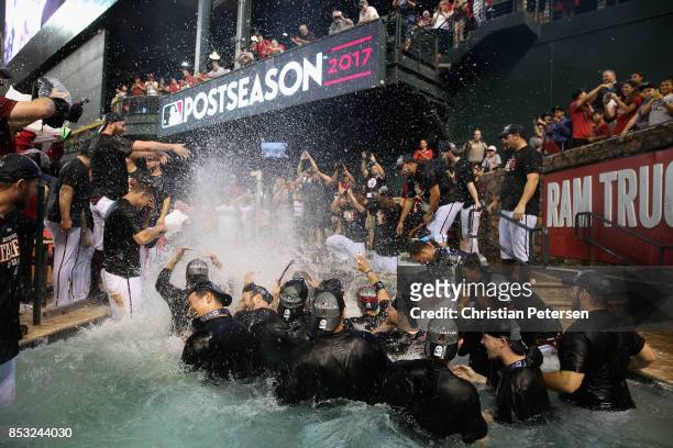 The Arizona Diamondbacks celebrate in the outfield pool after defeating the Miami Marlins and clinching a post season birth following the MLB game at...