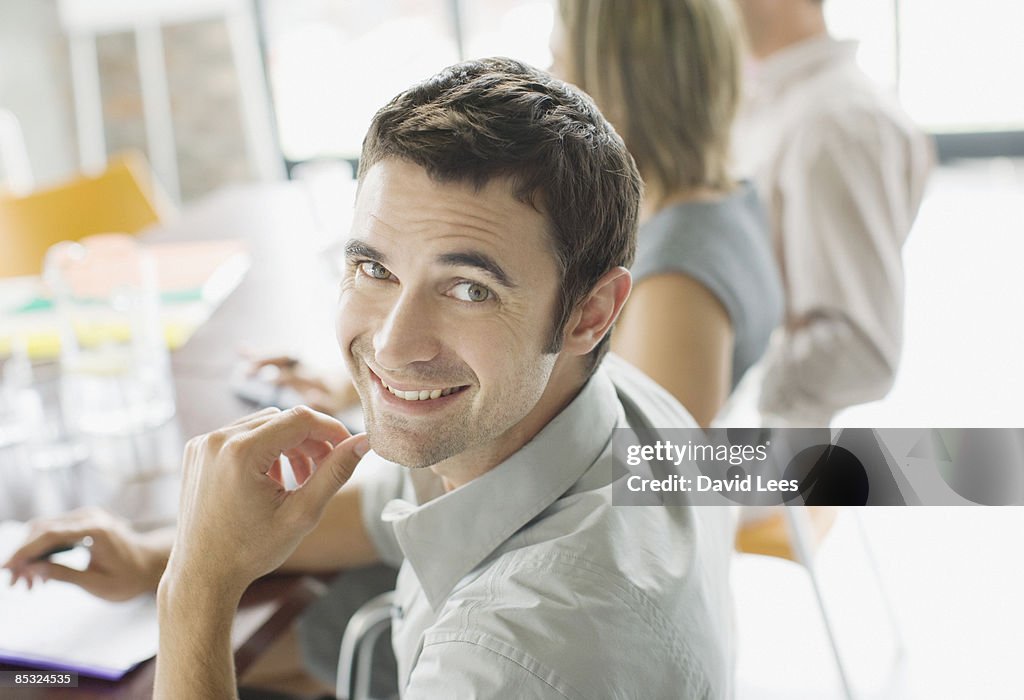 Businessman in meeting, smiling, portrait