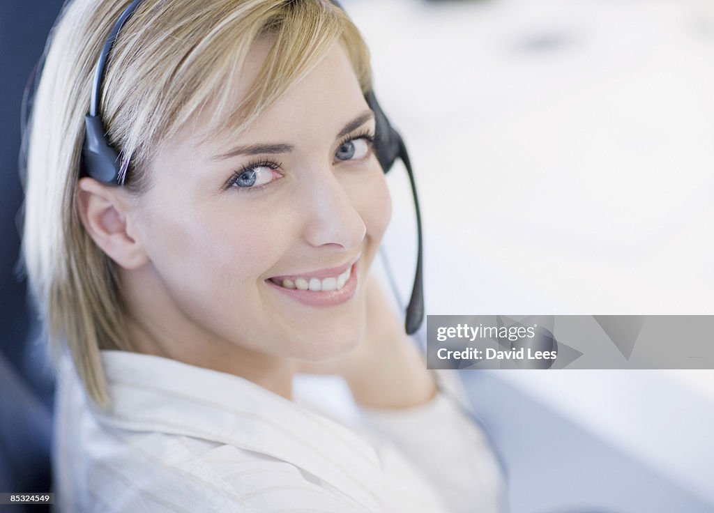 Businesswoman wearing headset, smiling, portrait