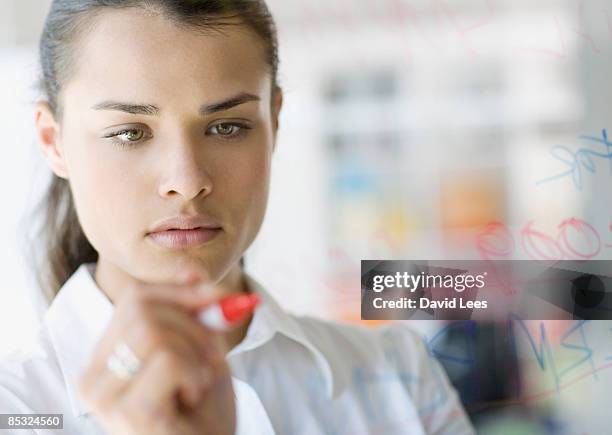 businesswoman writing on glass wall, close up - quadro transparente imagens e fotografias de stock