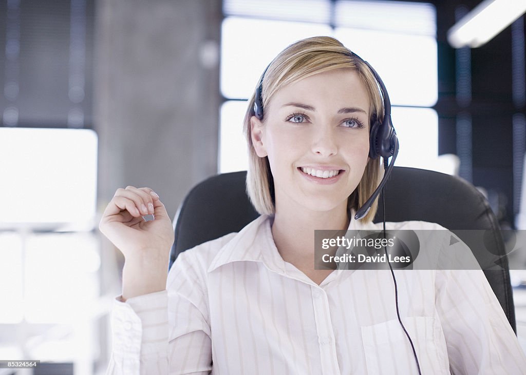 Businesswoman wearing headset, smiling