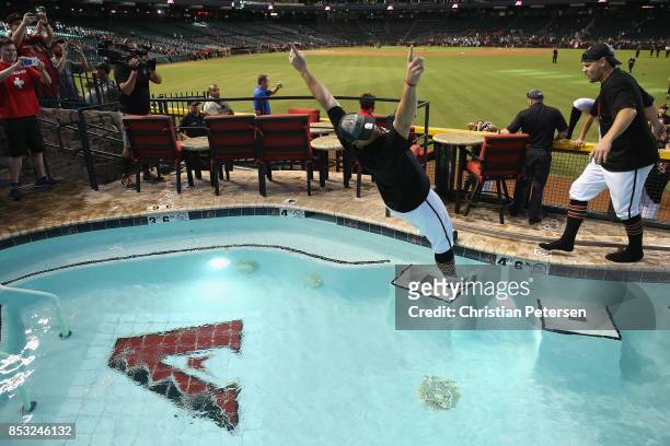 Pitcher Zack Godley of the Arizona Diamondbacks falls into the outfield pool after defeating the Miami Marlins and clinching a post season birth...