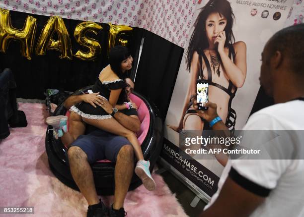 Graphic content / Japanese porn star Marica poses with a fan during the annual 'AdultCon' - Adult Entertainment Convention in Los Angeles, California...
