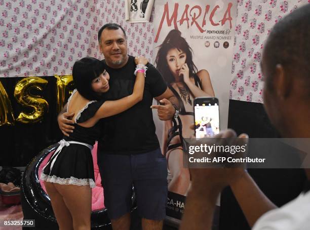 Graphic content / Japanese porn star Marica poses with a fan during the annual 'AdultCon' - Adult Entertainment Convention in Los Angeles, California...