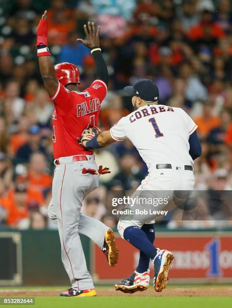 Carlos Correa of the Houston Astros tags out Brandon Phillips of the Los Angeles Angels of Anaheim in the second inning at Minute Maid Park on...