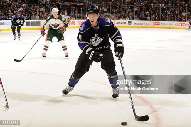 Oscar Moller of the Los Angeles Kings skates while Pierre-Marc Bouchard of the Minnesota Wild looks on during the game on March 7, 2009 at Staples...