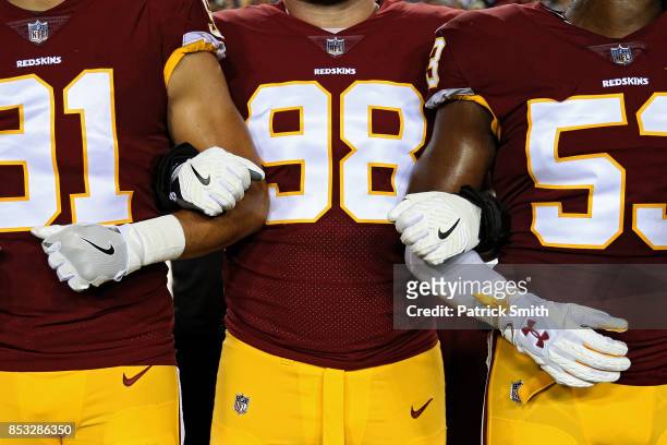 Defensive tackle Matthew Ioannidis of the Washington Redskins locks arms with teammates in unison during the national anthem before playing against...