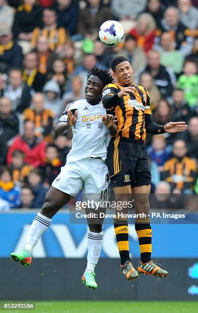 Swansea City's Wilfried Bony and Hull City's Curtis Davies jump for the ball during the Barclays Premier League match at the KC Stadium, Hull.