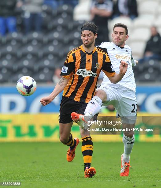 Hull City's George Boyd and Swansea City's Angel Rangel battle for the ball during the Barclays Premier League match at the KC Stadium, Hull.
