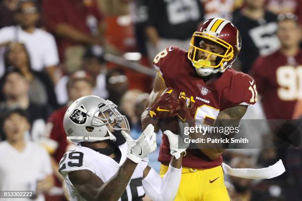 Wide receiver Josh Doctson of the Washington Redskins makes a catch over cornerback David Amerson of the Oakland Raiders in the third quarter at...