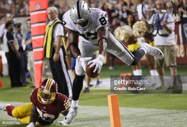 Tight end Jared Cook of the Oakland Raiders scores a touchdown over strong safety Deshazor Everett of the Washington Redskins in the third quarter at...