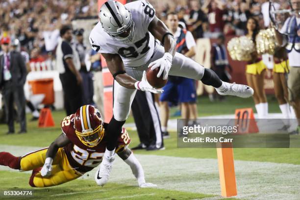 Tight end Jared Cook of the Oakland Raiders scores a touchdown over strong safety Deshazor Everett of the Washington Redskins in the third quarter at...