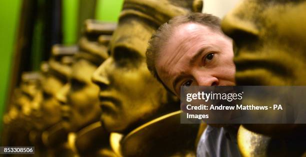 Lee Batty, Head of Production for the Olivier Awards, adjusts a model of an Olivier Award statue during preparations for The Olivier Awards 2014...