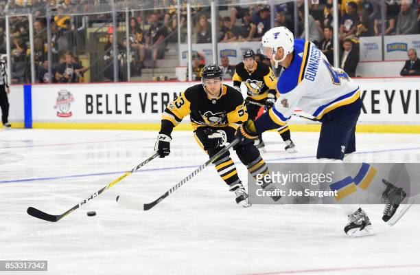 Carl Gunnarsson of the St. Louis Blues moves the puck in front of Teddy Blueger of the Pittsburgh Penguins at UPMC Lemieux Sports Complex on...