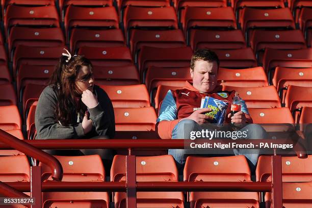 Burnley fans in the stands read the match day programme