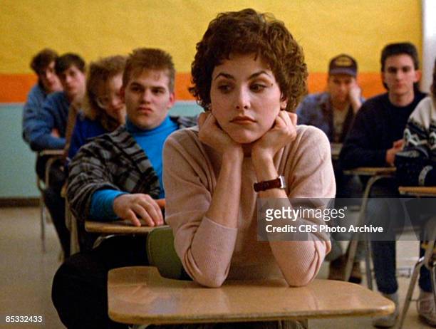 American actress Sherilyn Fenn sits in a classroom set with her chin in her hands in a scene screen grab from the pilot episode of the television...