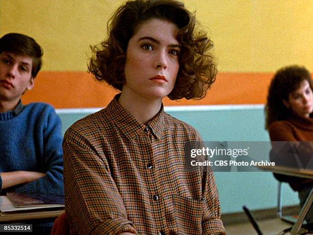 American actress Lara Flynn Boyle sits as a desk in a classroom set in a scene screen grab from the pilot episode of the television series 'Twin...