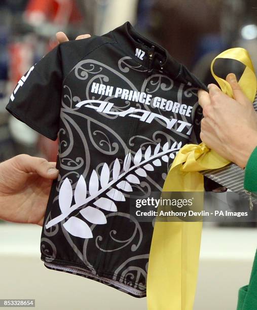 The Duke and Duchess of Cambridge react as they receive a baby cycling top printed with Prince George's name as they open the Hamilton Avantidrome...