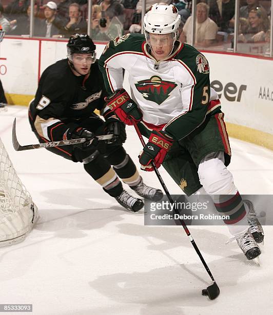 Kim Johnsson of the Minnesota Wild drives the puck behind the net against Bobby Ryan of the Anaheim Ducks during the game on March 8, 2009 at Honda...