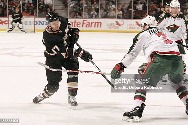 Marek Zidlicky of the Minnesota Wild reaches across Petteri Nokelainen of the Anaheim Ducks as he passes the puck during the game on March 8, 2009 at...