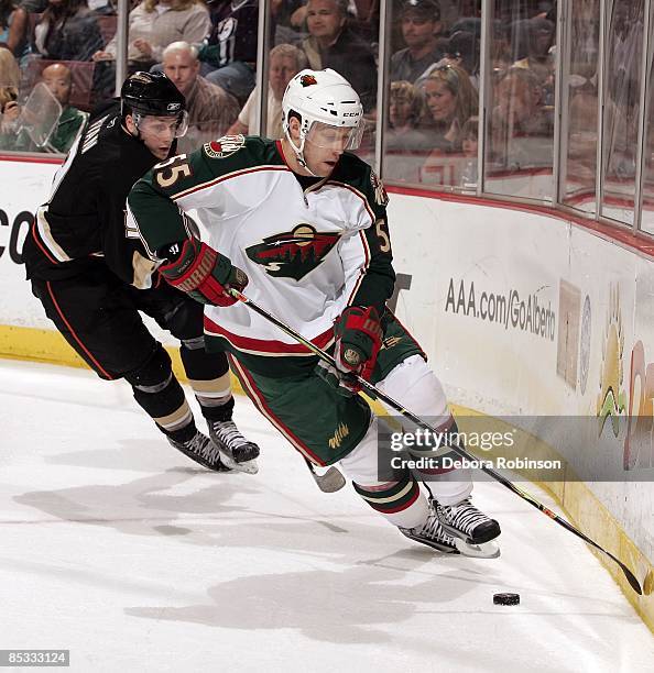 Nick Schultz of the Minnesota Wild handles the puck behind the net against Bobby Ryan of the Anaheim Ducks during the game on March 8, 2009 at Honda...