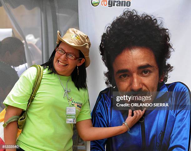 Woman poses next to poster of the singer of Mexican alternative rock band Cafe Tacuba, Ruben Albarran, in Tegucigalpa on March 10, 2009. Albarran,...