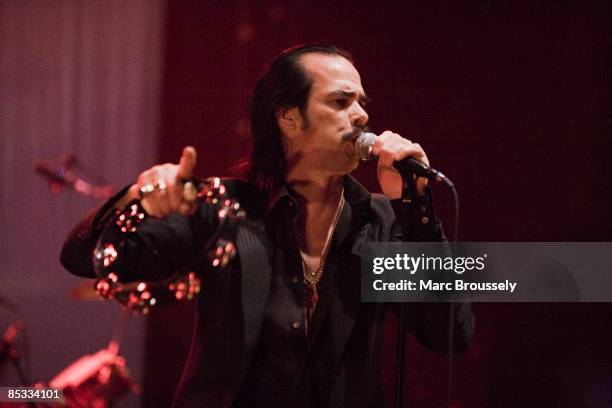 Photo of Nick CAVE & THE BAD SEEDS and Nick CAVE, Nick Cave performing on stage, tambourine