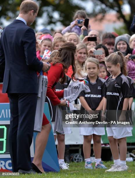 The Duke and Duchess of Cambridge receive a baby cricket shirt with the name Cambridge on the back as they watch a 2015 Cricket World Cup event in...