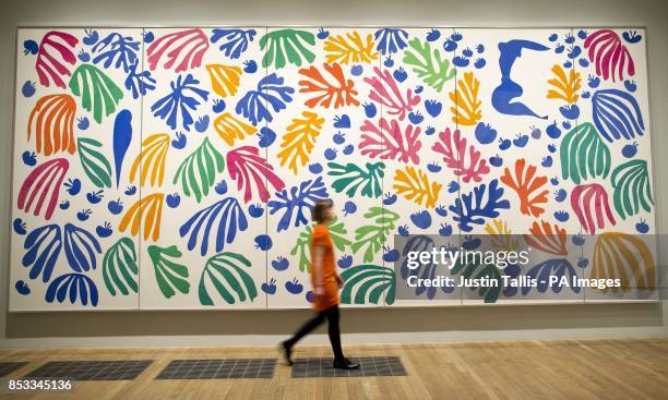 Gallery assistant walks past The Parakeet and the Mermaid 1952 by Henri Matisse at The Cut-Outs exhibition at the Tate Modern, London.