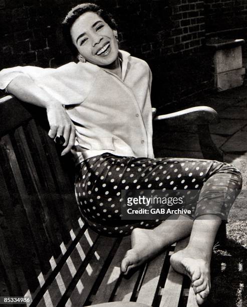 Photo of Shirley BASSEY; Posed portrait of Shirley Bassey, sitting on bench