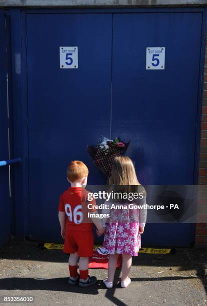 Tommy, aged two, and his sister Millie Biggadike, aged four, whose grandfather Thomas Howard died in the tragedy look at tributes outside the...