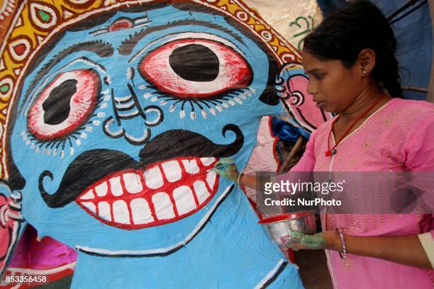 Members of a traditional artist family applying colors into the masks of Ravan ahead of the Ravan Podi feistival in the eastern Indian state Odisha's...