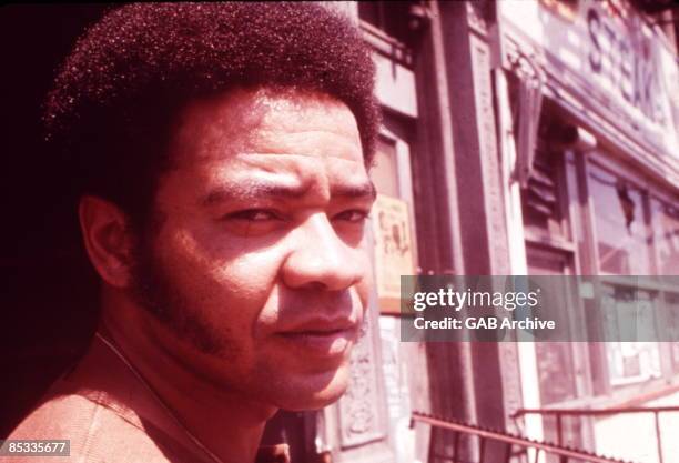 Photo of Bill WITHERS; Posed portrait of Bill Withers in the street