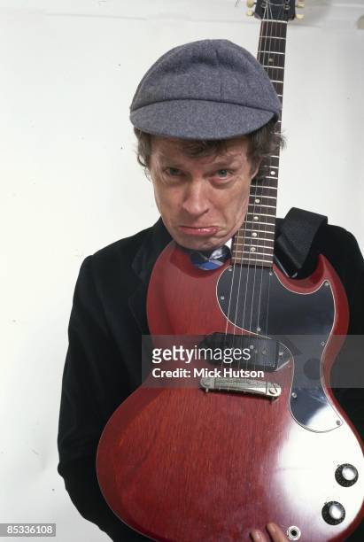 Photo of Angus YOUNG and AC/DC; Posed studio portrait of Angus Young, Gibson SG Junior guitar