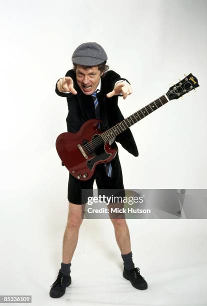 Photo of Angus YOUNG and AC/DC; Posed studio portrait of Angus Young, Gibson SG Junior guitar