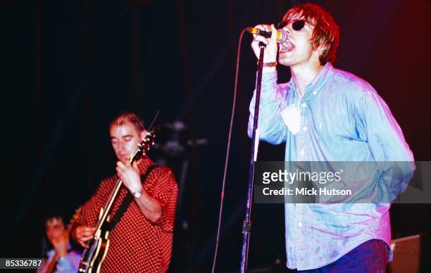 Photo of Paul Bonehead ARTHURS and Liam GALLAGHER and OASIS; Paul 'Bonehead' Arthurs and Liam Gallagher performing on stage, sunglasses