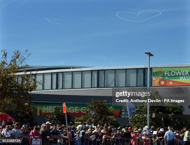 Plane leaves a vapour trail display in the air as the Duke and Duchess of Cambridge visit the Royal Easter Show at Sydney Olympic Park during the...