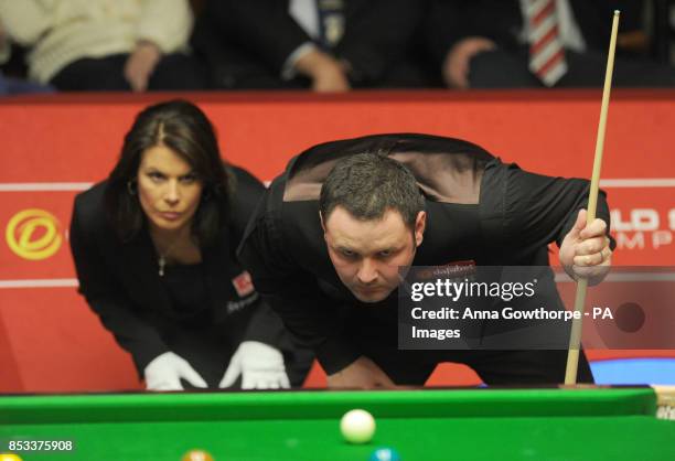 Stephen Maguire studies the table alongside referee Michaela Tabb in his first round match against Ryan Day during the Dafabet World Snooker...