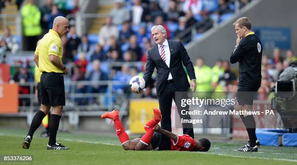 Stoke City manager Mark Hughes looks towards referee Howard Webb as Cardiff City's Kevin Theophile Catherine lies on the floor after he was tackled...