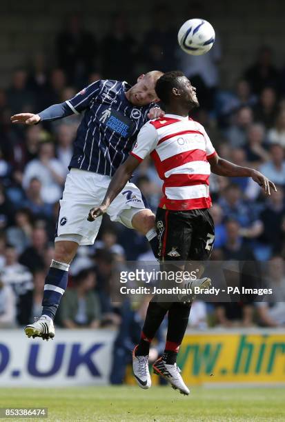 Millwall's Alan Dunne leaps with Doncaster's Theo Robinson during the Sky Bet Championship match at The New Den, London.