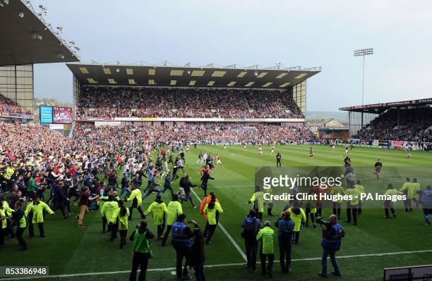 Burnley's fans celebrate by invading the pitch after their side win promotion to the Premier League during the Sky Bet Championship match at Turf...