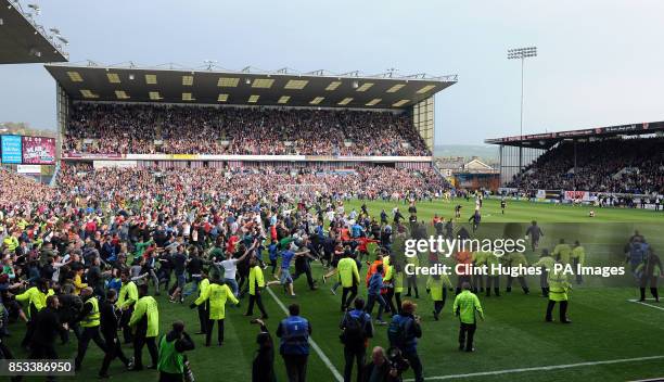 Burnley's fans celebrate by invading the pitch after their side win promotion to the Premier League during the Sky Bet Championship match at Turf...