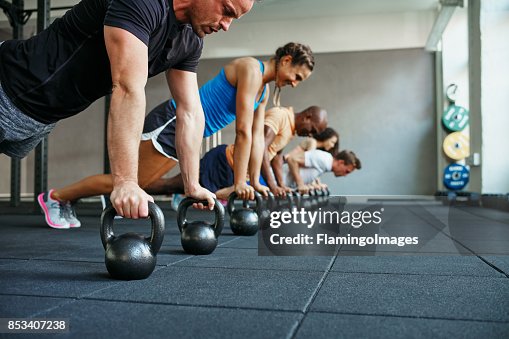 People doing pushups together in a health club class People doing pushups together in a health club class