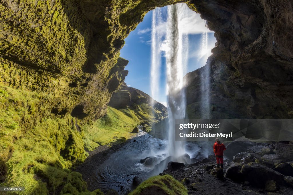 Wanderer am majestätischen Kvernufoss Wasserfall in Island